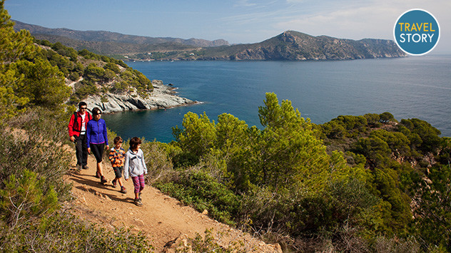 Eine Familie wandert auf einem Küstenwanderweg in Katalonien. 