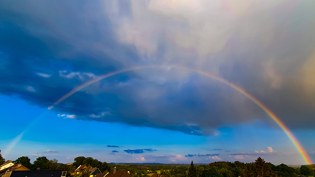 Ein Regenbogen spannt sich über einen Ort