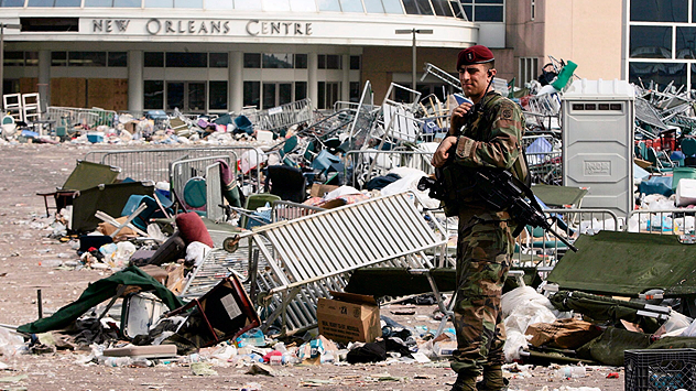 Ein Soldat steht bewaffnet vor dem New Orleans Centre, umgeben von Trümmern und Müll.