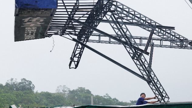 Werbetafel - © dpa Werbetafeln, die von dem Sturm umkippt sind, werden beseitigt.