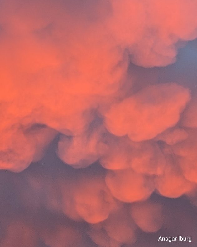 Orange-rote Wolken im Morgenlicht mit weicher, dichter Struktur.