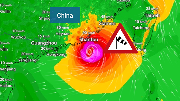 Wetterkarte der südchinesischen Küste und Taiwans mit einem kräftigen tropischen Wirbelsturm. Das Auge des Sturms liegt nahe der Küstenstadt Shantou in der chinesischen Provinz Guangdong. Um den Kern zeigen intensive Rot-, Pink- und Violetttöne Orkanböen, während ein großes orangefarbenes Windfeld bis zur Westküste Taiwans reicht. Ein eingeblendetes Windsack-Warnschild weist auf gefährliche Sturmwinde hin. Städte wie Hongkong, Guangzhou, Xiamen, Taipeh und Taichung sind eingezeichnet, ebenso Windgeschwindigkeiten und weiße Strömungslinien, die die zyklonale Luftzirkulation veranschaulichen.