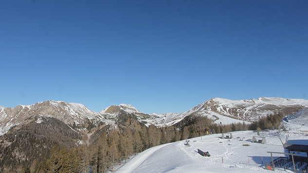 Das Webcambild zeigt ein Skigebiet bei strahlend blauem Himmel.