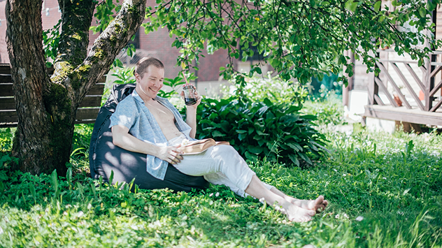 © Grusho Anna / Shutterstock.com Mann sitzt unterm Baum im Schatten