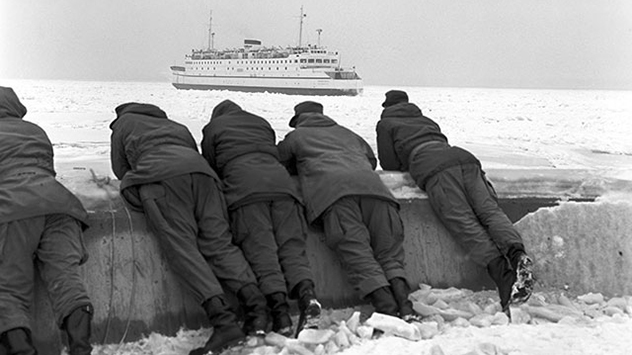 Passanten beobachten in Kiel die Fähre der Vogelfluglinie, die sich mühsam durch das zusammengeschobene Packeis der Ostsee kämpft.