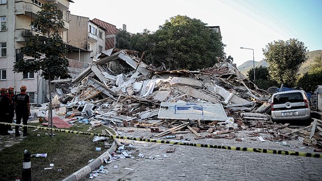 Rescue workers search through the rubble of a collapsed house after the earthquake in Balikesir (Turkey).