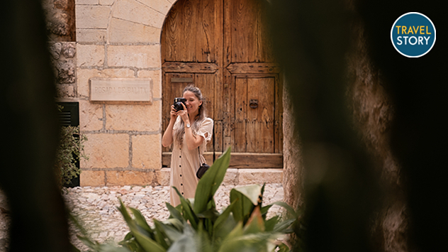 Eine Frau macht ein Foto von einer historischen Gasse auf Mallorca,