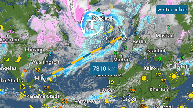 Wetterkarte mit Temperaturen und einem 7310-km-Routenpfeil über dem Atlantik. Symbole zeigen Sonne, Wolken und Niederschlag von Nordamerika bis Europa.