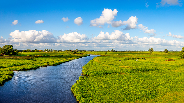 Sonniges Wetter mit Quellwolken über einer Flusslandschaft