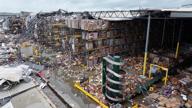 Side view of a multi-story Dollar Tree distribution warehouse heavily damaged after a tornado.