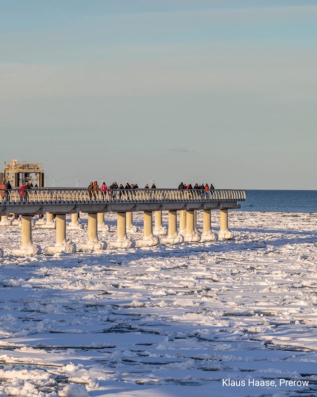 Sonniger Februartag an der Seebrücke in Prerow mit Eisschollen auf der Ostsee