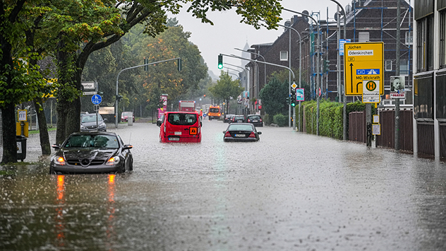 Cars stand in a flooded street in Mönchengladbach, which is under water after heavy rain.