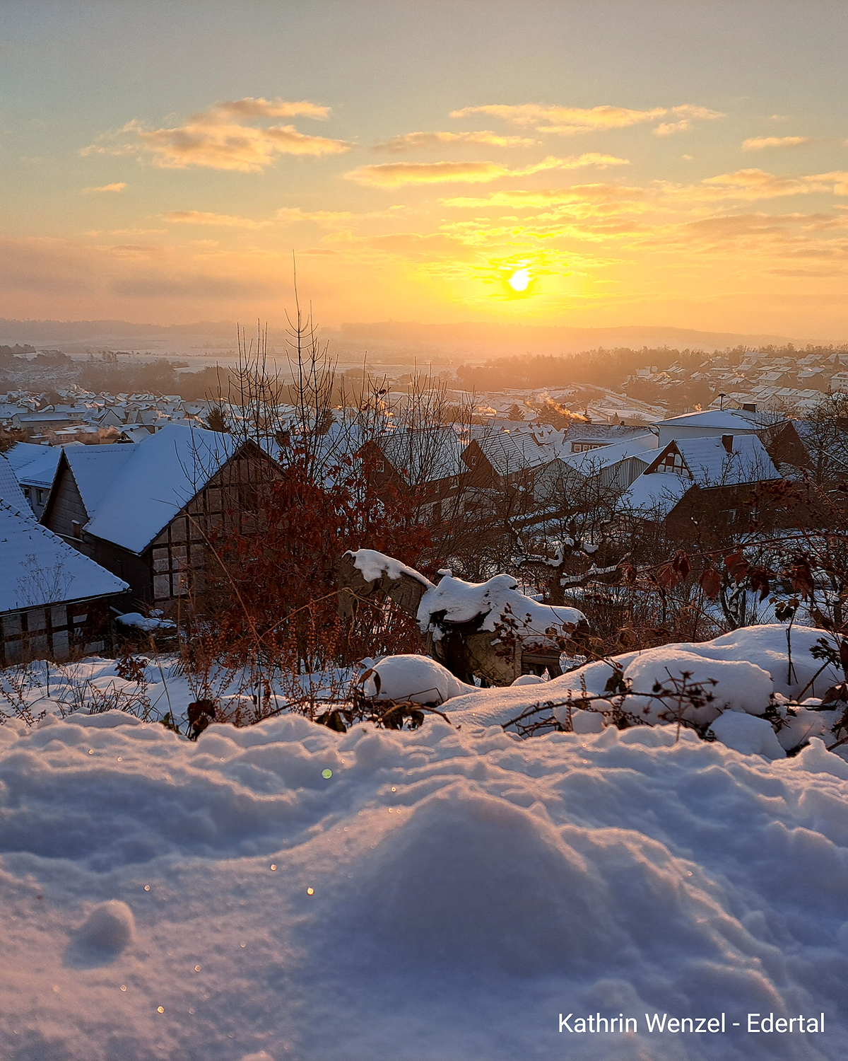 Sonnenaufgang über verschneitem Ort im Edertal