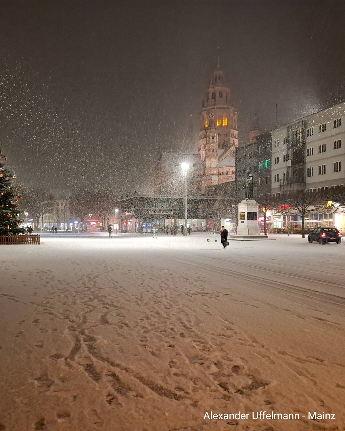 Verschneiter Marktplatz in Mainz mit Dom im Hintergrund und Schneefall