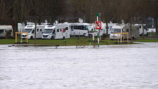 Wohnmobile stehen nahe der Mündung der Hochwasser führenden Mosel in den Rhein auf einem Campingplatz in Koblenz.