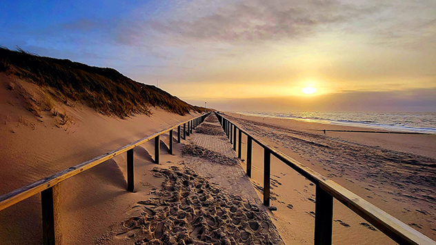 Im Westerland auf Sylt ist die Sonne noch am Horizont zu sehen. 