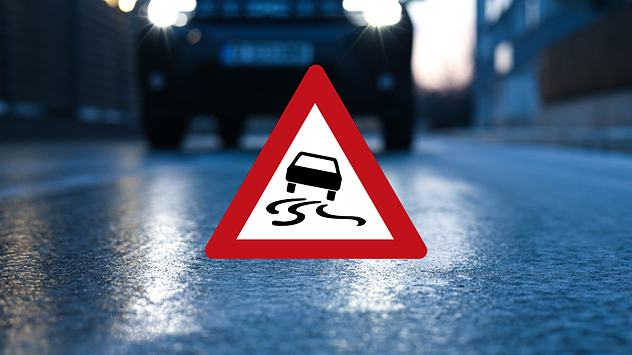 Glatte Straße und eine Glättewarnung