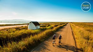 (c) Patronat-de-Turisme-de-la-Diputació-de-Tarragona-INVERTIDA Zwei Radfahrer unterwegs im Ebrodelta. (c) Patronat-de-Turisme-de-la-Diputació-de-Tarragona-INVERTIDA