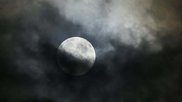 eilweise verfinsterter Vollmond am Nachthimmel, umgeben von dramatisch beleuchteten, dunklen Wolken â stimmungsvolle Mondbeobachtung. (c) Andrea Beck