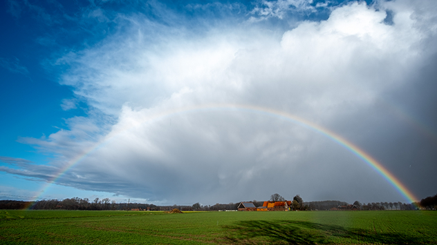 Ein abziehender April-Schauer mit Regenbogen im Sonnenlicht.