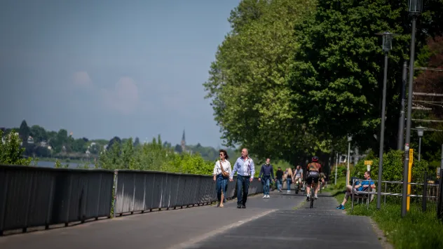 Das angenehm warme Wetter mit Höchstwerten bis 21 Grad lädt zum Flanieren auf den Promenaden ein, wie hier in Königswinter am Rhein.