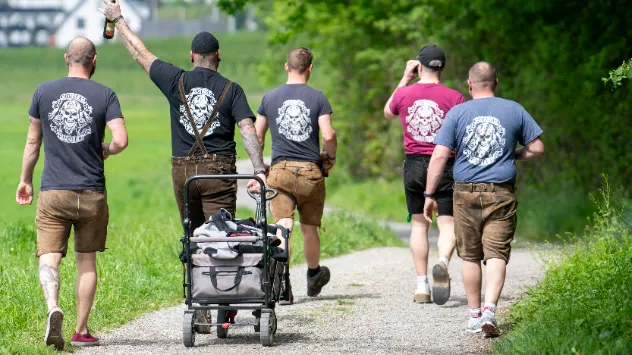 Männergruppe mit Bollerwagen unterwegs
