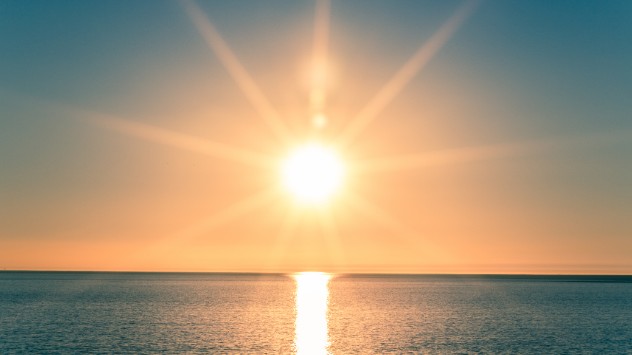 Sun sets behind ocean