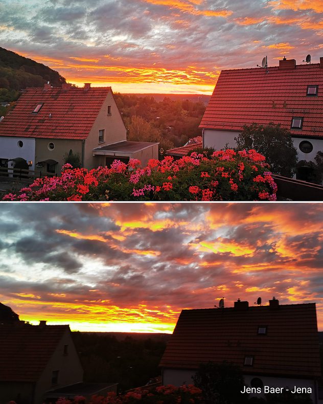 Der Sonnenuntergang taucht die Unterkante der Wolken in leuchtendes Orange. Der Blick geht über Hausdächer.