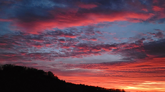 Wolken leuchten in kräftigen Rot- und Oranangetönen über Schleiz