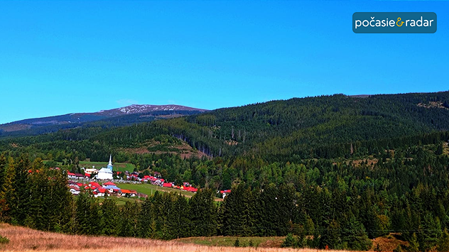 Jasná obloha a lesy naookolo.