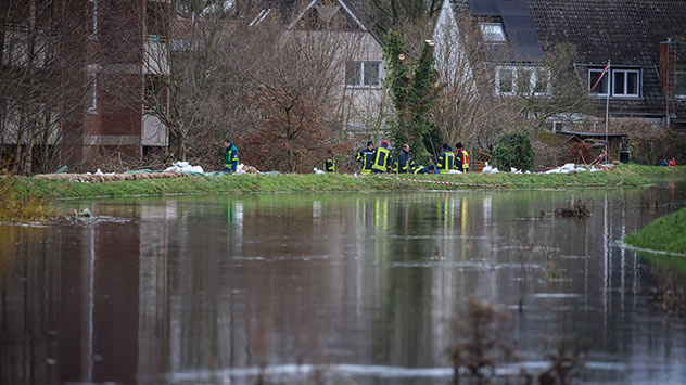 In Lilienthal bei Bremen kontrollieren Einsatzkräfte die Sandsäcke auf einem Deich. 
