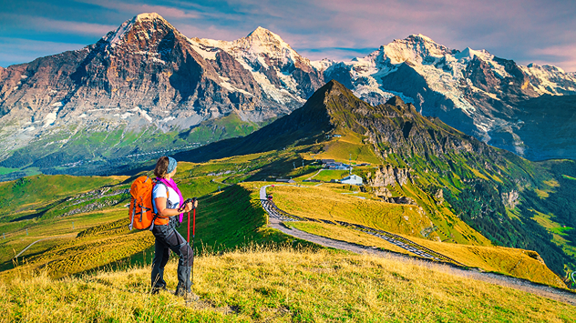 Eine Frau beim Wandern, im Hintergrund Eiger, Mönch und Jungfrau