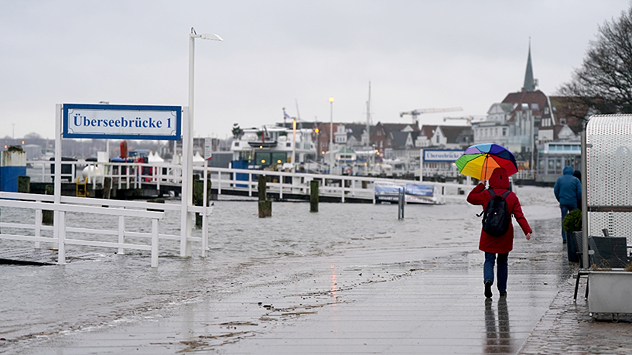 Das Wasser der aufgestauten Trave schwappt auf die Travepromenade in Lübeck.