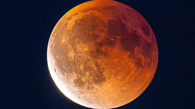 Close-up of the red moon during an eclipse over Travemünde. Craters and structures appear in reddish light.