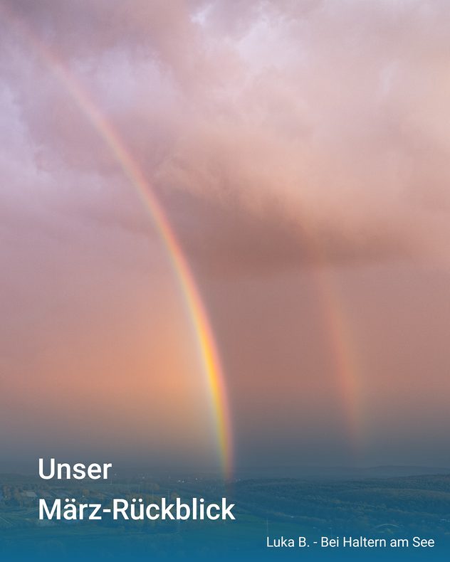 Regenbogen spannt sich über eine Landschaft unter dichten Wolken. Im Hintergrund Felder und Hügel, Licht bricht durch die Wolkendecke.