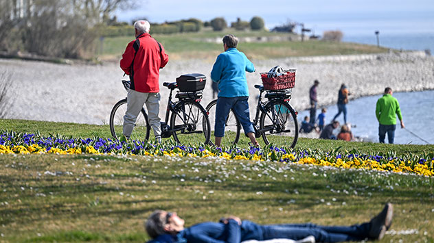 Menschen genießen den Sonnenschein am Bodensee.
