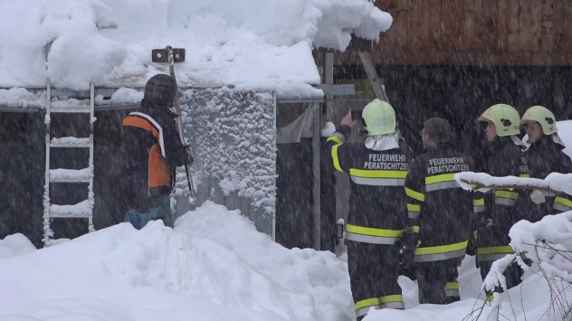 Ein Dach wird abgeschaufelt.