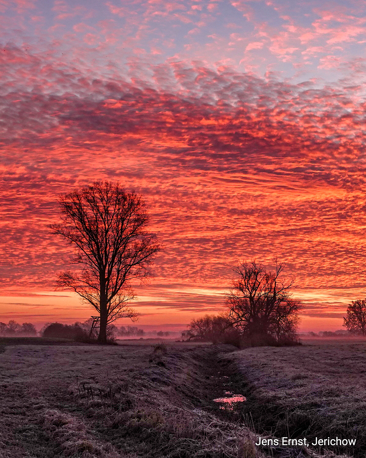 © Jens Ernst Tiefroter Abendhimmel mit strukturierten Wolken über einer dunklen Landschaft. Intensives Lichtspiel kurz nach Sonnenuntergang.