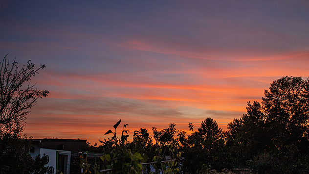 Über der sächsischen Landeshauptstadt Dresden färben sich besonders die hohen Wolken  orange bis rot.