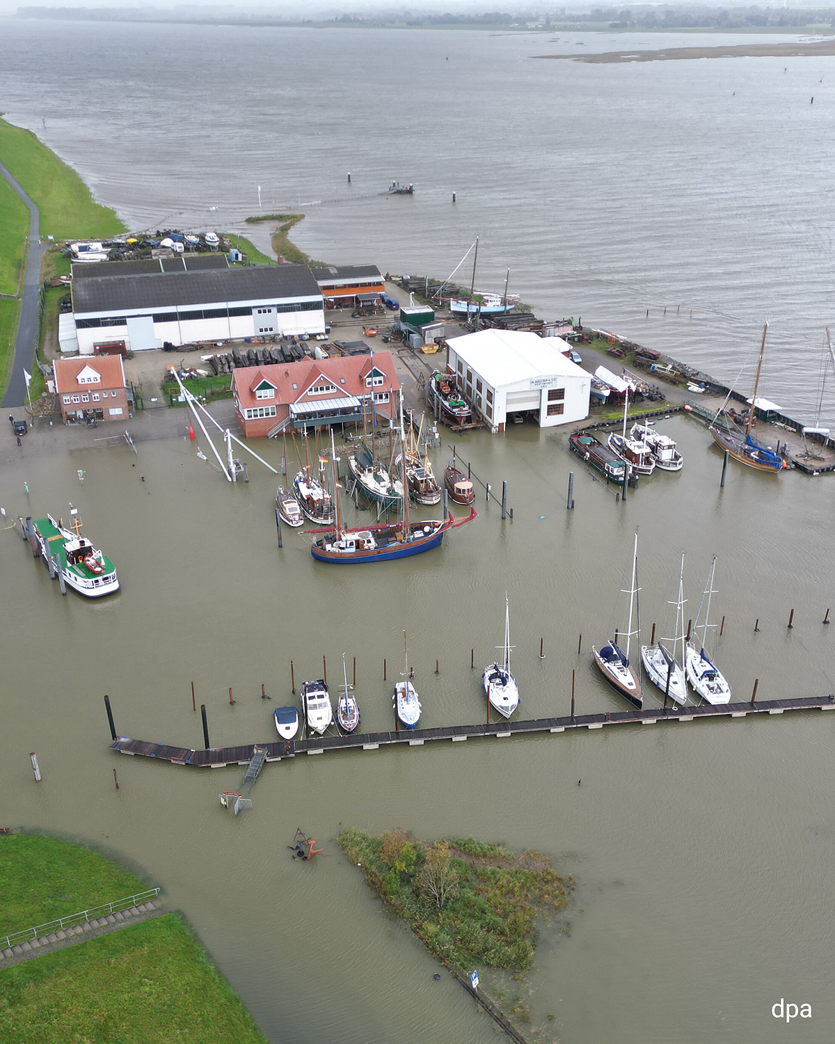 Luftbild eines überfluteten Hafens am Dollart, Boote liegen im Wasser, Stege und Gebäude sind teilweise überschwemmt.