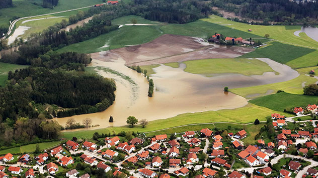 Überflutete Wiese vor Ortschaft
