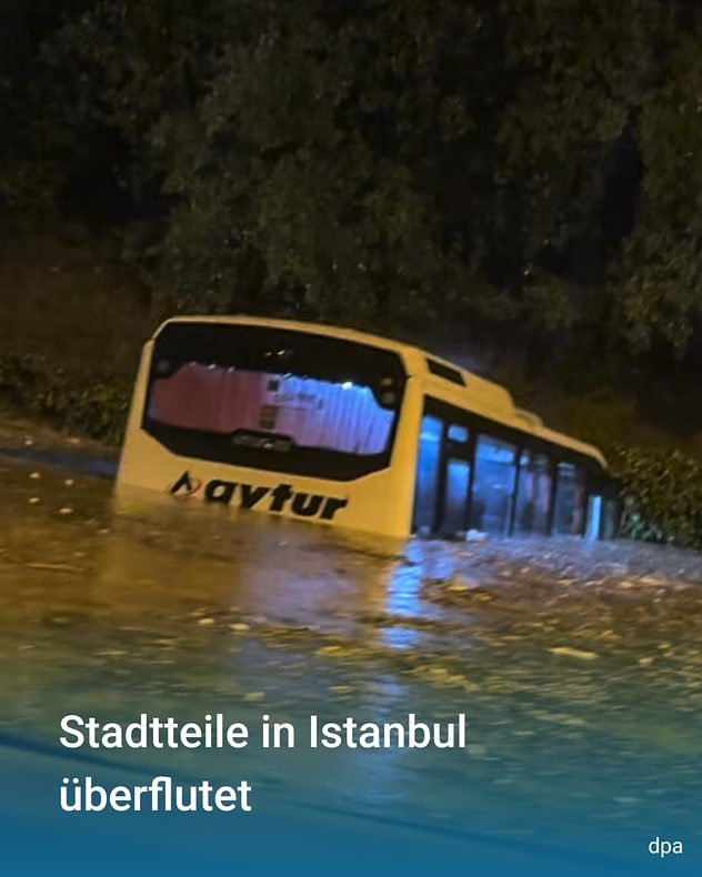 V Istanbulu stojí žlutý autobus hluboko v povodňové vodě. Hnědá voda sahá až k oknům a proudí po stranách vozidla.