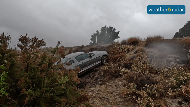Car slides off I-8 in California after rains make roads very slippery. 