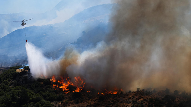 Ein Löschhubschrauber wirft Wasser auf einen Waldbrand bei Izmir ab.