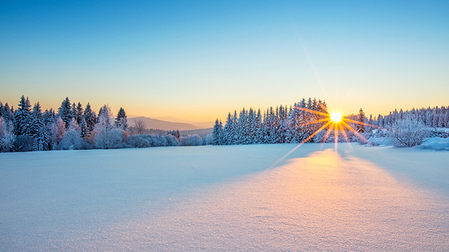 Снимка на величествен изгрев в зимен планински пейзаж.