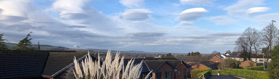 LinsenfÃ¶rmige Wolken (Lenticularis) am Himmel Ã¼ber Ruthin, Nordwales â sie erscheinen glatt und elliptisch, fast wie ein UFO, vor blauem Himmel mit vereinzelten Wolken. Typisch fÃ¼r wellenfÃ¶rmige Luftbewegungen in der NÃ¤he von Bergen.v (c) Vince Gill