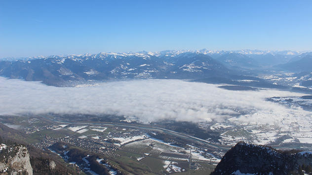Das Webcambild zeigt den Blick von einem Berg. Im Tal liegt etwas Nebel.