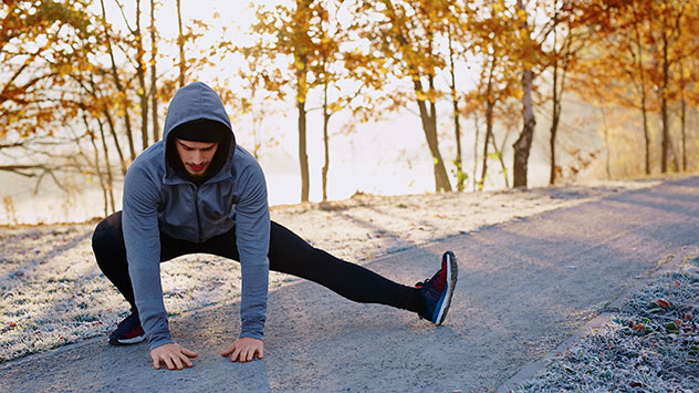 Ein Mann wärmt sich vor dem Joggen auf. 