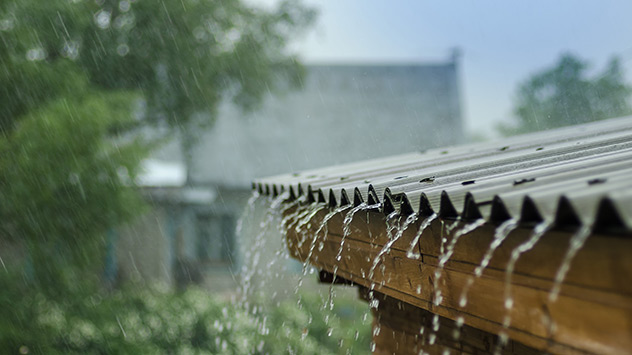 Regen fließt von einem Dach herunter