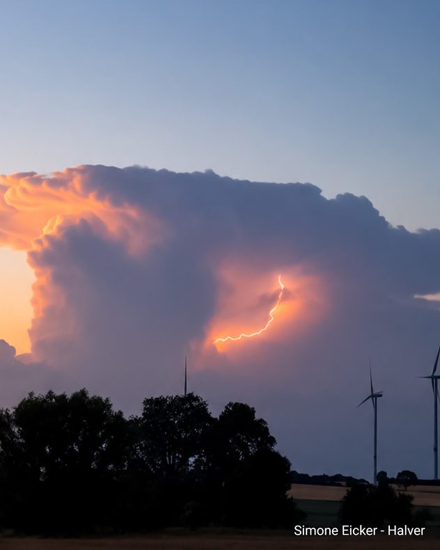 Eine mächtige Gewitterwolke blitzt im Abendlicht über dem Sauerland.